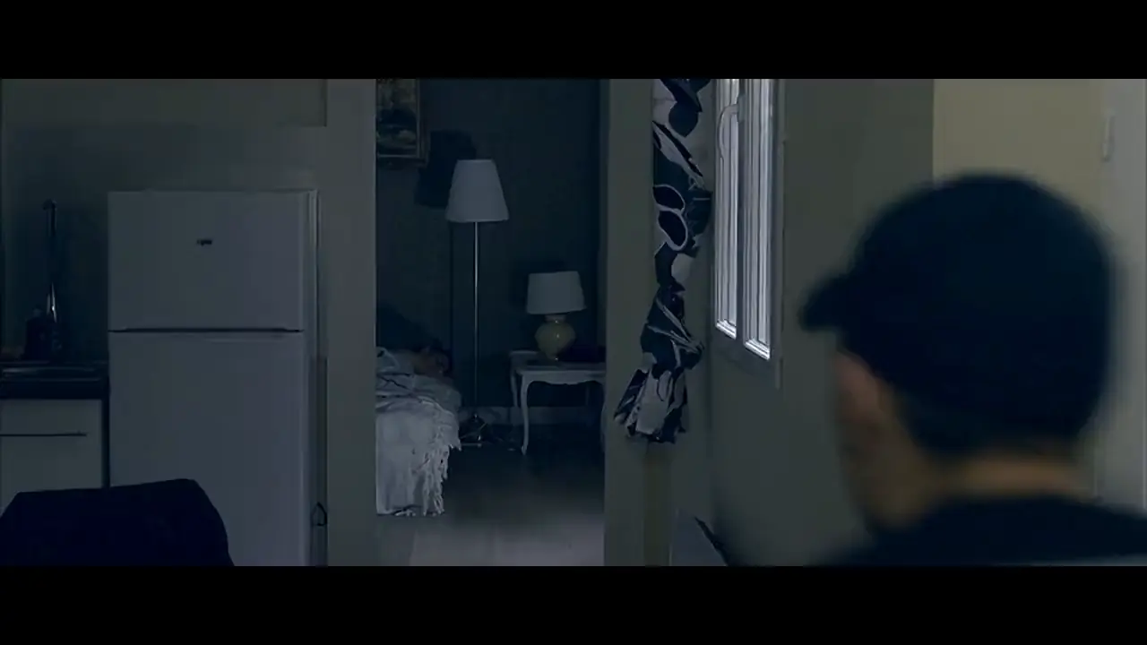 Homme en casquette, de dos, dans un appartement